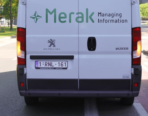 De achterkant van een bestelwagen met in groene letters merak op de deur